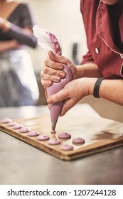 Process Of Making Macaron Macaroon, French Dessert, Squeezing The Dough Form Cooking Bag. Food Industry, Mass Or Volume Production.