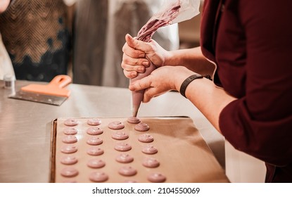 Process Of Making Macaron Macaroon, French Dessert, Squeezing The Dough Form Cooking Bag. Food Industry, Mass Or Volume Production.