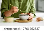 Process Of Making Matcha Tea Involves A Woman Pouring Tea Into A Bowl