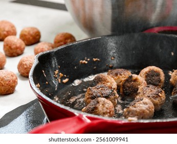 The process of making swedish meatballs. Raw meatballs cooking in a cast iron pan on the stove. Trasitional cuisine. Cooking in the kitchen. 