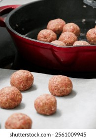 The process of making swedish meatballs. Raw meatballs cooking in a cast iron pan on the stove. Trasitional cuisine. Cooking in the kitchen. 