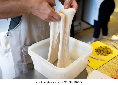 The process of making wheat bread in an artisan bakery. The folding of the dough during fermentation. Front view. - Powered by Shutterstock