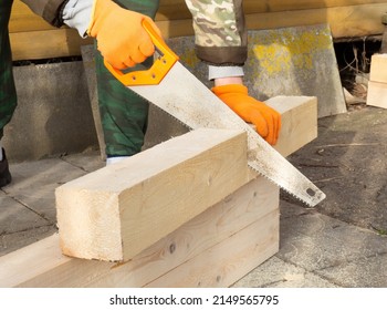 The process of manual sawing timber. a man sawing a timber when building a house