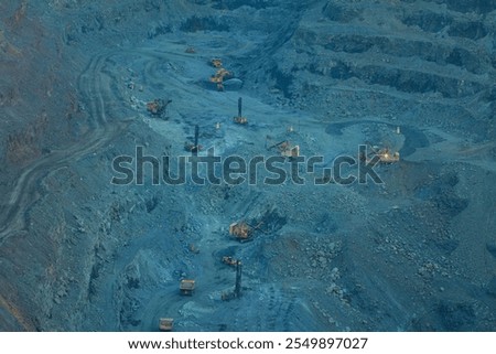 The process of open-pit mining in a quarry for the extraction of minerals. Open pit mining of iron ore with the help of large equipment, the bowl of the pit 