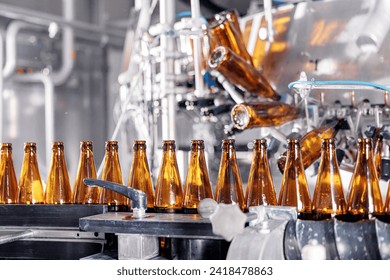 Process pasteurization of bottles on conveyor machinery of brewery. Germ removal and glass cleaning before bottling beer drink.