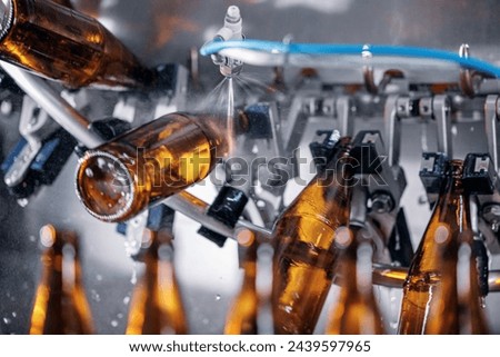 Process pasteurization Brown plastic bottles with beer, moving on conveyor. Concept production line of brewery, modern food industry