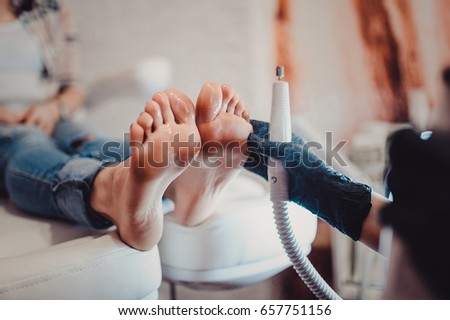 Process of pedicure at beauty salon spa. The process of pedicure in a professional beauty salon. Process of processing the toes by a special machine. Care of the skin of the feet. another view