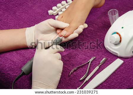 Process pedicure close-up, polishing fingernail, unrecognizable people