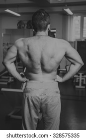 The process of physical exercise with dumbbells. The man is engaged in the gym. Training in the gym. Healthy lifestyle. Photo in creative.