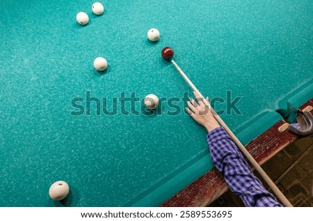 The process of playing billiards with a cue in hand at the billiard table of Russian billiards.