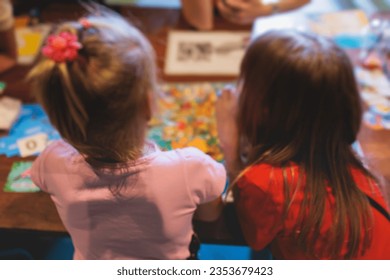 Process of playing board game and having fun with friends and family in room indoors, board game concept, group of kids children play board games at the table, roll the dice 