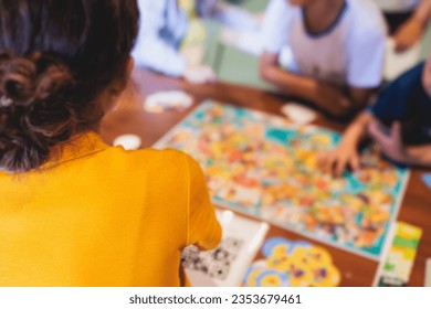 Process of playing board game and having fun with friends and family in room indoors, board game concept, group of kids children play board games at the table, roll the dice 