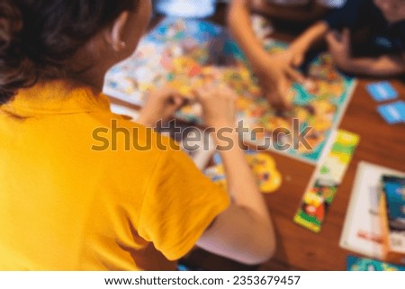 Process of playing board game and having fun with friends and family in room indoors, board game concept, group of kids children play board games at the table, roll the dice 