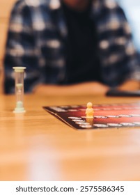 Process of playing tabletop board game on the table, fun with friends and family in room indoors, board game party concept, company group of students adults play board games, roll the dice on game map
