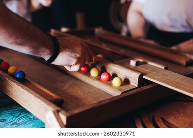 Process of playing tabletop board game on the table, fun with friends and family in room indoors, board game party concept, company group of students adults play board games, roll the dice on game map