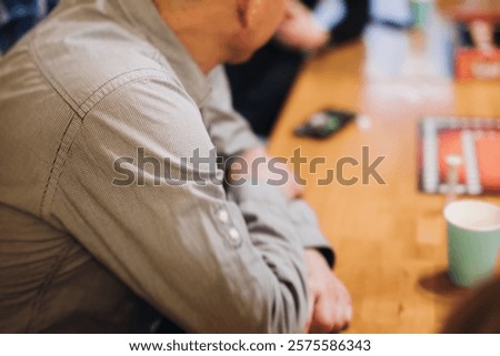 Process of playing tabletop board game on the table, fun with friends and family in room indoors, board game party concept, company group of students adults play board games, roll the dice on game map