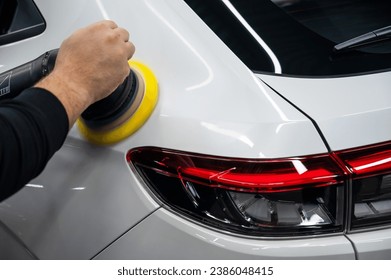 Process of polishing white car body surface using orbital polishing machine.  - Shutterstock ID 2386048415