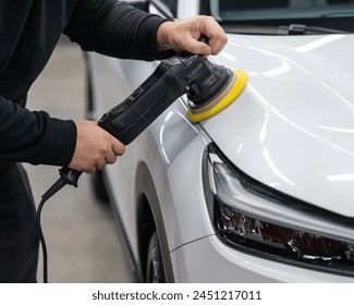 Process of polishing white car hood surface using orbital polishing machine.  - Powered by Shutterstock