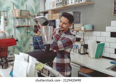 Process Of Pouring Coffee Beans Into The Grinder