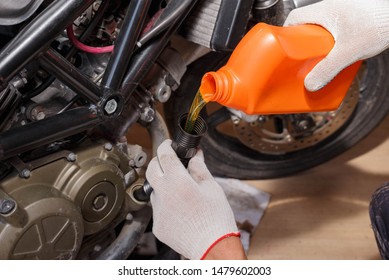 The Process Of Pouring New Oil Into The Motorcycle Engine. Motorcycle Service.