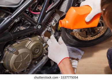 The process of pouring new oil into the motorcycle engine. Motorcycle service. - Shutterstock ID 1537775054