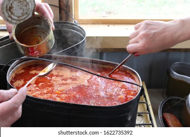 The process of preparing camping borsch in a boiler on a fire in a campsite in the Caucasus mountains, Karachay-Cherkessia, Russia. Tasty and healthy camping food. - Shutterstock ID 1622735392