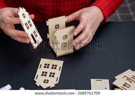 Process of preparing for Christmas and New Year eve. 3D craft wooden houses DIY. Responsible ecological zero waste handmade decoration. Children hobby activity