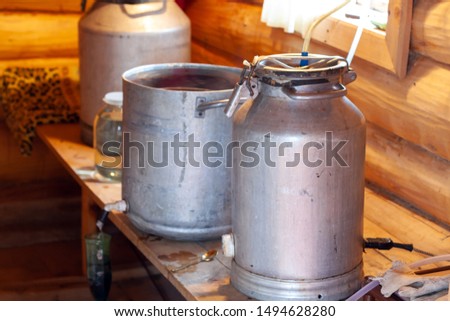 The process of preparing moonshine in a village bath in a primitive moonshine distilling-apparatus. Moonshine. Manufacture of moonshine in Russia.