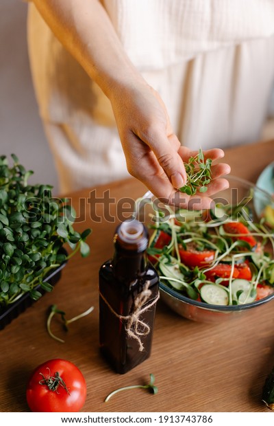 The process of preparing a salad with microgreens\
and natural oil. Add sprouts to food. Healthy food rich in vitamins\
and nutrients bio eco. Vegan bowl. Lifestyle kitchen table. Low\
calorie diet