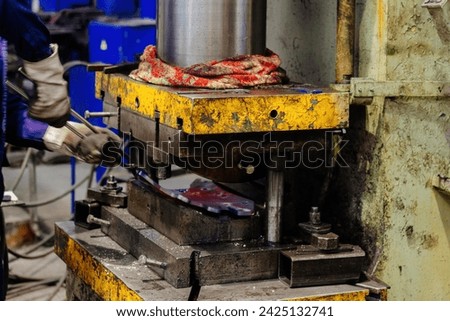 Process of pressing and quenching of hot iron part, close up.