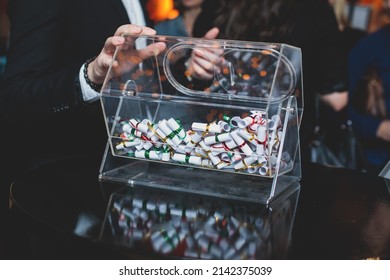 Process Of Prize Drawings, Extracting A Winning Numbers Of Lottery Machine, Raffle Drum With A Bingo Balls And Winning Tickets On Event With A Host And Hands On Lottery Machine
