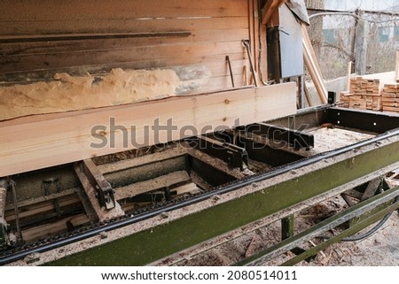 The process of processing logs and wooden planks on sawmill equipment. Timber industry. Sawing, drying wood