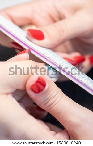 The process of professional manicure and preparation for applying gel polish in the salon. Macro photo of female fingers.
