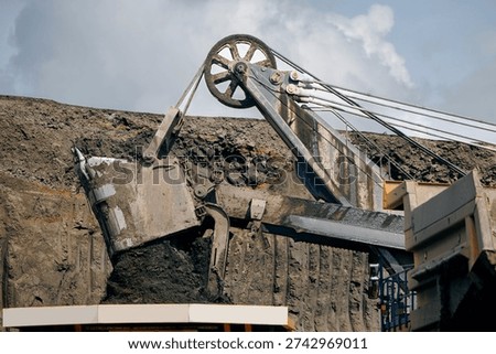 Process of removing overburden soil in quarry. Industrial machinery at open pit coal mine extracting resources.