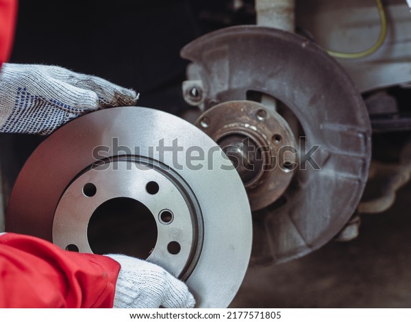 Process of replacing brake discs with\
Brand new. Auto mechanic repairing in garage Car\
brakes