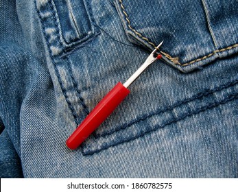 The process of ripping threads on jeans with a special tool Ripper.
