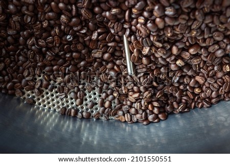 The process of roasting a batch of high quality single origin coffee beans in a large industrial roaster the toasted beans are in the cooling cycle.