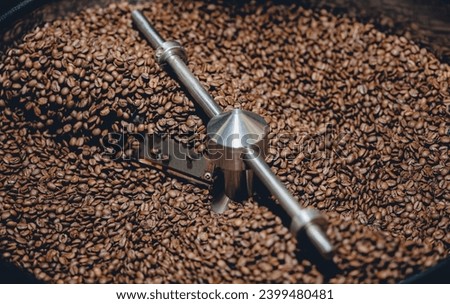 Process roasting brown coffee beans on professional mixing roaster industry machines