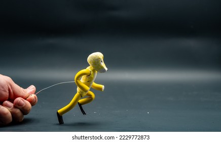 Process of running stopmotion. Start of running. Man's hand holding with aluminum wire a figure created with modeling paste. The 12 principles of animation.