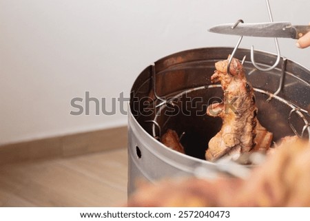 Process of serving meat after smoking in barrel. Removing smoked cuts ready for the final dish.