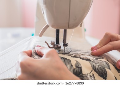 Process Of Sewing The Curtains At Home, Close Up Of Curtain Tape On The Sewing Machine, Hemming, Tailoring, Repairing And Stitching Cloth And Dress, With The Hand Of Female Dressmaker In Background
