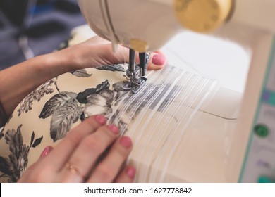 Process Of Sewing The Curtains At Home, Close Up Of Curtain Tape On The Sewing Machine, Hemming, Tailoring, Repairing And Stitching Cloth And Dress, With The Hand Of Female Dressmaker In Background
