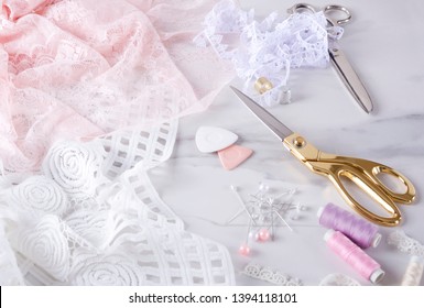Process of sewing elegent lingerie.Sewing process, golden and silver scissors, pins, spools of thread and pins