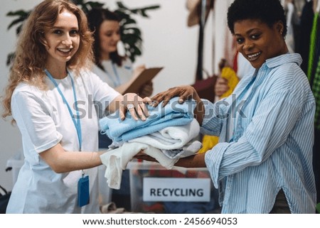 Process of sorting textile for donation, charity, recycling. Young students doing volunteer project, collecting clothes for university second hand store, swap party, garage sale. Eco friendly living