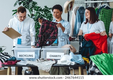 Process of sorting textile for donation, charity, recycling. Young students doing volunteer project, collecting clothes for university second hand store, swap party, garage sale. Eco friendly living