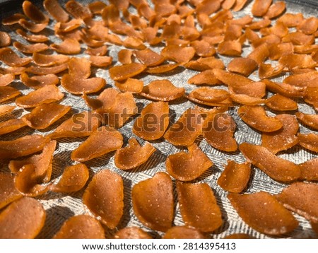 The process of sun-drying fish-based crackers, requiring consistent, intense sunlight.