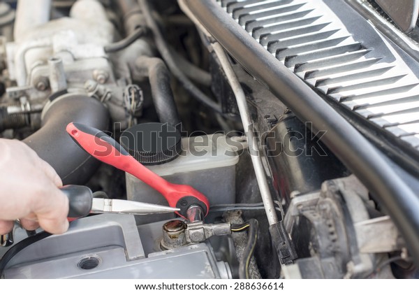 The process of tightening bolts to fix the the\
vehicle battery