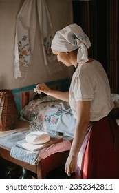 The process of traditional baking of bread at home. A woman in national Ukrainian dress bakes bread.