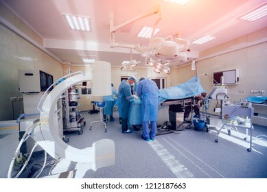 Process Of Trauma Surgery Operation. Group Of Surgeons In Operating Room With Surgery Equipment. Medical Background