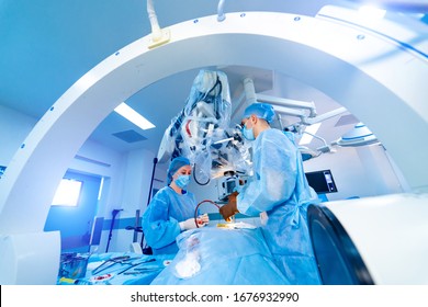 Process Of Trauma Surgery Operation. Group Of Surgeons In Operating Room With Surgery X-ray Equipment. Medical Background